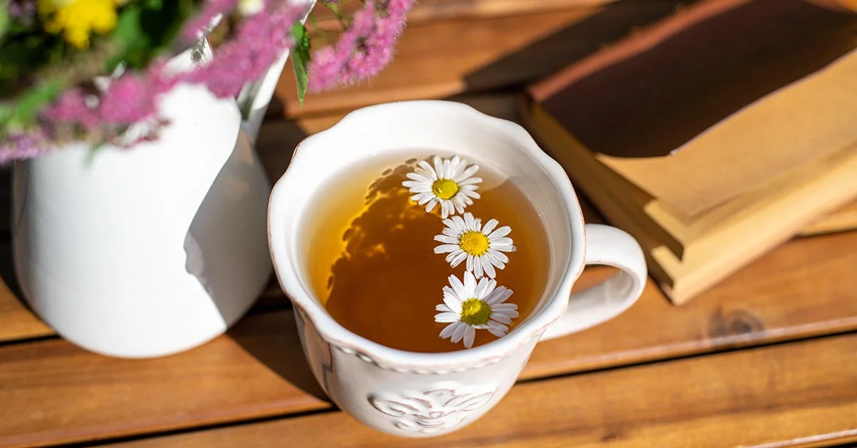 Tasse de tisane de camomille sur table rustique en bois. Tisane à la camomille, bouquet de fleurs des prés et bloc-notes. Médecine alternative, phytothérapie, concept de pharmacie naturelle