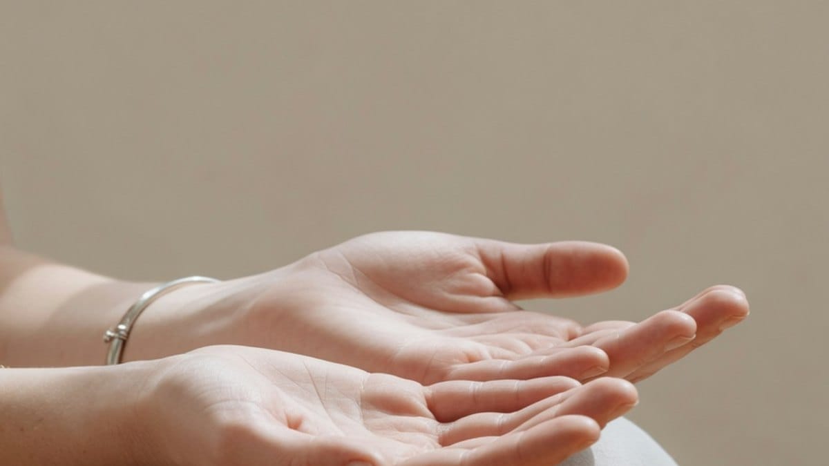 Mains posées ouvertes sur les genoux dans une posture de méditation apaisée