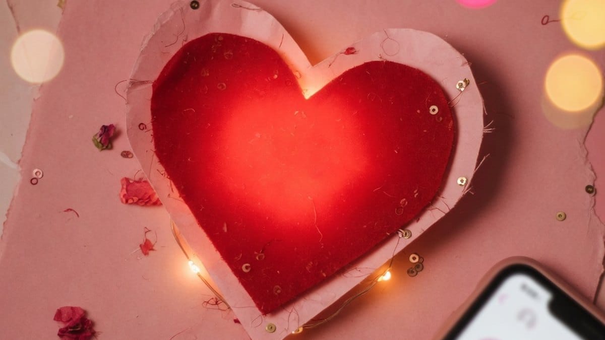 Cœur rouge lumineux posé sur un fond doux évoquant une conversation amoureuse en ligne